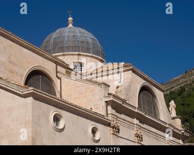 Cupole della chiesa e architettura storica di una città vecchia sotto un cielo azzurro, la città vecchia di Dubrovnik con case storiche, chiese, tetti rossi e. Foto Stock