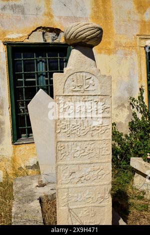 Cimitero turco, cimitero islamico, cimitero Mohammedan, lapide storica con iscrizioni di fronte a un vecchio muro in parte sbriciolato e finestre Foto Stock