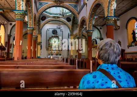 AGUADAS, COLOMBIA - 15 GENNAIO 2024: Donna anziana presso lo storico Tempio dell'Immacolata Concezione nel centro storico del patrimonio culturale di Foto Stock