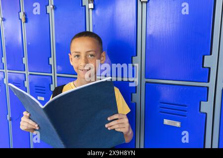Il ragazzo birazziale si trova davanti agli armadietti della scuola, con spazio per le copie Foto Stock