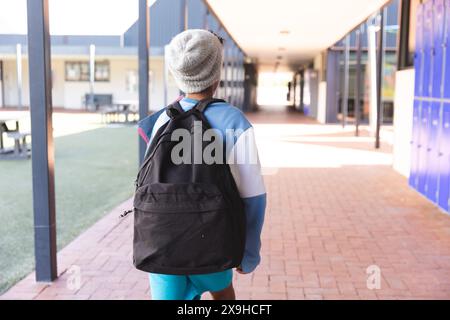 Il ragazzo birazziale cammina attraverso il corridoio scolastico, con spazio per le copie Foto Stock