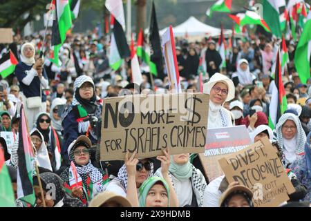 GIACARTA, INDONESIA - 1° GIUGNO: Un manifestante pro-palestinese regge un cartello con la scritta "No More for Israel's Crime” durante la manifestazione pro-palestinese presso l'ambasciata statunitense di fronte a Giacarta, Indonesia, il 1° giugno 2024. La manifestazione ha protestato contro l'attacco militare israeliano a Rafah, Gaza. Foto Stock