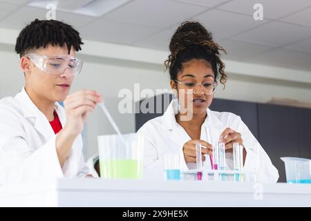 Adolescente birazziale e adolescente indefinita in un laboratorio alle superiori Foto Stock