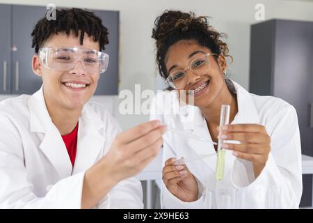 Adolescente birazziale e adolescente birazziale in un laboratorio alle superiori Foto Stock