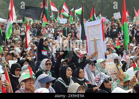 GIACARTA, INDONESIA - 1° GIUGNO: Manifestanti pro-palestinesi, con bandiere e bandiere palestinesi, si riuniscono fuori dall'ambasciata degli Stati Uniti per mostrare sostegno ai palestinesi a Giacarta, Indonesia, il 1° giugno 2024. La manifestazione ha protestato contro l'attacco militare israeliano a Rafah, Gaza. Foto Stock