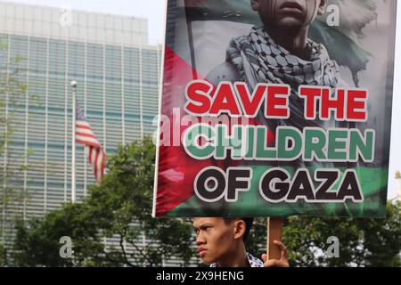 GIACARTA, INDONESIA - 1° GIUGNO: Un manifestante pro-palestinese regge un cartello con la scritta "Save the Children of Gaza” durante la manifestazione pro-palestinese presso l'ambasciata statunitense di fronte a Giacarta, Indonesia, il 1° giugno 2024. La manifestazione ha protestato contro l'attacco militare israeliano a Rafah, Gaza. Foto Stock