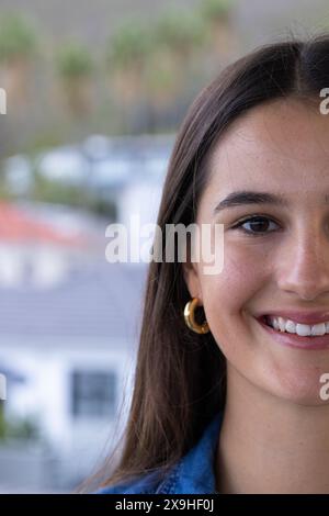 A casa, giovane donna caucasica con lunghi capelli marroni sorridente calorosamente, copia spazio Foto Stock