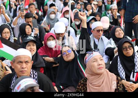 GIACARTA, INDONESIA - 1 GIUGNO: Una protesta pro-palestinese alza i pugni durante la manifestazione pro-palestinese presso l'ambasciata statunitense di fronte a Giacarta, Indonesia, il 1° giugno 2024. La manifestazione ha protestato contro l'attacco militare israeliano a Rafah, Gaza. Foto Stock