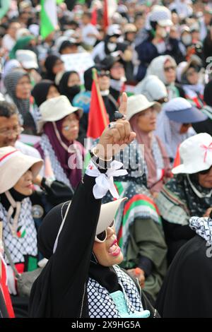 GIACARTA, INDONESIA - 1 GIUGNO: Una protesta pro-palestinese alza i pugni durante la manifestazione pro-palestinese presso l'ambasciata statunitense di fronte a Giacarta, Indonesia, il 1° giugno 2024. La manifestazione ha protestato contro l'attacco militare israeliano a Rafah, Gaza. Foto Stock