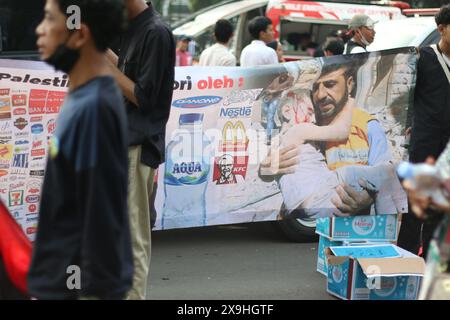 GIACARTA, INDONESIA - 1° GIUGNO: Un profanatore palestinese, uno striscione che chiede il boicottaggio dei prodotti associati a Israele durante la manifestazione pro-palestinese presso l'ambasciata statunitense di fronte a Giacarta, Indonesia, il 1° giugno 2024. La manifestazione ha protestato contro l'attacco militare israeliano a Rafah, Gaza. Foto Stock