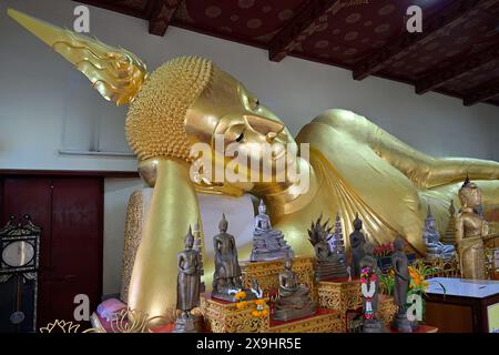 Dettaglio di Buddha reclinato dorato con fiamma che emerge dall'ushnisha sulla sua testa, Wat Phra Pathommachedi, Nakhon Pathom, Thailandia Foto Stock