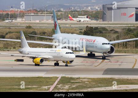 Barcellona, Spagna - 14 aprile 2024: Air Canada Boeing 777-300ER e Vueling Airbus A320 sulla pista di rullaggio all'aeroporto El Prat di Barcellona, Spagna Foto Stock