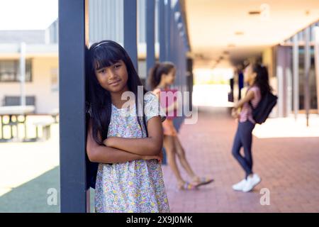 A scuola, tre giovani studentesse birazziali si trovano all'aperto nel corridoio Foto Stock