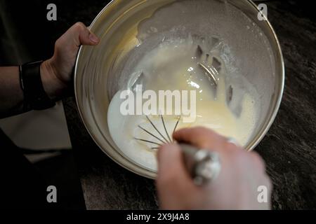 Il composto per torte viene frullato in un recipiente Foto Stock