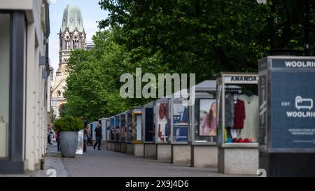 31 maggio 2024, Berlino: Ci sono numerose vetrine sul marciapiede lungo Kurfürstendamm. Kurfürstendamm, conosciuta anche come Ku'damm, è una delle più grandi vie dello shopping di Berlino ed è considerata un punto di riferimento della capitale. La torre della chiesa commemorativa del Kaiser Wilhelm può essere vista sullo sfondo foto: Monika Skolimowska/dpa Foto Stock