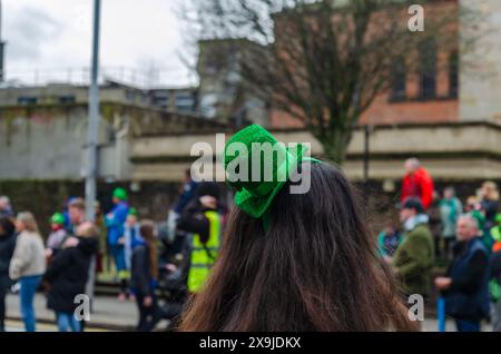 Belfast, Contea di Antrim, Irlanda del Nord 17 marzo 2024 - primo piano da dietro di una donna che indossa un cappello da leprechaun alla parata di San Patrizio Foto Stock