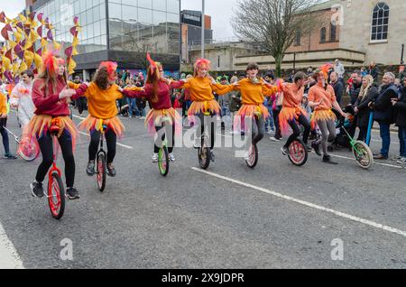 Belfast, Contea di Antrim, Irlanda del Nord 17 marzo 2024 - gruppo di ragazze che si esibiscono su unicicli nella sfilata del giorno di San Patrizio a Belfast Foto Stock