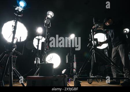 Il regista regola l'illuminazione della fotocamera sul set Foto Stock