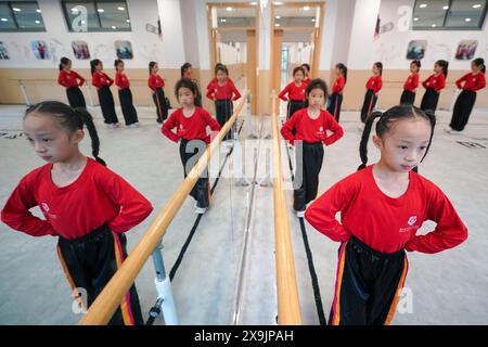 (240601) -- KUNSHAN, 1° giugno 2024 (Xinhua) -- gli alunni prendono un corso di formazione per l'Opera di Kunqu presso la Scuola primaria del Centro Shipai di Kunshan nella città di Kunshan, nella provincia cinese di Jiangsu, 30 maggio 2024. In una sala di formazione della Scuola primaria del Centro Shipai nella città di Kunshan, gli alunni esercitano le competenze di base dell'Opera di Kunqu sotto la guida di un insegnante a tempo pieno. Tutte le manovre sono presentate con precisione. La città di Kunshan è il luogo di nascita dell'Opera di Kunqu, elencata dall'Organizzazione delle Nazioni Unite per l'educazione, la scienza e la cultura (UNESCO) come patrimonio culturale immateriale. La città ha stabilito il suo Foto Stock