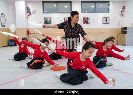 (240601) -- KUNSHAN, 1° giugno 2024 (Xinhua) -- gli alunni della "Little Kunqu Opera training class" praticano fan dance sotto la guida dell'insegnante Wu Meiyu (C) presso la Shipai Center Primary School di Kunshan nella città di Kunshan, nella provincia cinese orientale di Jiangsu, 30 maggio 2024. In una sala di formazione della Scuola primaria del Centro Shipai nella città di Kunshan, gli alunni esercitano le competenze di base dell'Opera di Kunqu sotto la guida di un insegnante a tempo pieno. Tutte le manovre sono presentate con precisione. La città di Kunshan è il luogo di nascita dell'Opera di Kunqu, elencata dall'Organizzazione delle Nazioni Unite per l'educazione, la scienza e la cultura Foto Stock