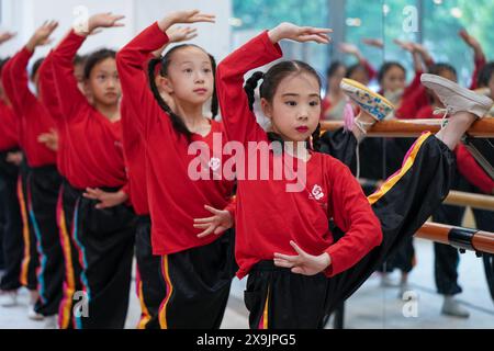 (240601) -- KUNSHAN, 1° giugno 2024 (Xinhua) -- Xie Suqian (front), allieva della "Little Kunqu Opera training class", pratica le competenze di base dell'opera Kunqu con i suoi compagni di classe presso la Shipai Center Primary School di Kunshan nella città di Kunshan, nella provincia cinese orientale di Jiangsu, 30 maggio 2024. In una sala di formazione della Scuola primaria del Centro Shipai nella città di Kunshan, gli alunni esercitano le competenze di base dell'Opera di Kunqu sotto la guida di un insegnante a tempo pieno. Tutte le manovre sono presentate con precisione. La città di Kunshan è il luogo di nascita dell'Opera Kunqu, elencata dalle Nazioni Unite Educational, Scientific e cUL Foto Stock