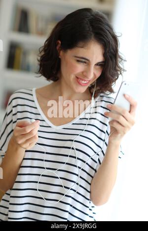 Donna che ascolta musica con lo smartphone. Foto Stock
