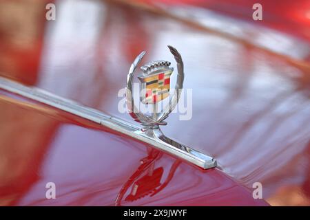 Un segno di Cadillac su una parte anteriore di un'auto rossa Foto Stock