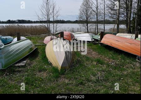 Barche rovesciate sulla riva del lago in Finlandia Foto Stock