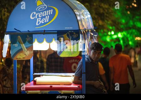 Gelateria Bell carrello per gelati di notte con gente che lo circonda che mostra l'estate delle ondate di caldo in India Foto Stock