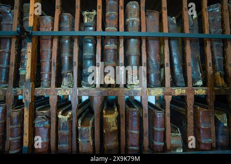 Molti, molti vecchi libri di copertina rigida rilegati in pelle su una libreria. Libreria piena di libri antichi rari, una raccolta di libri d'epoca. Foto Stock