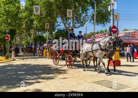 La Fiera di aprile di Siviglia (Feria de Abril de Sevilla o Fiera di Siviglia) con carrozze trainate da cavalli, colorate tende da festival e strade cittadine decorate. Foto Stock