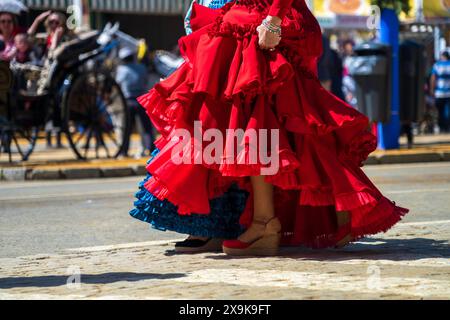 Donna con un tradizionale abito rosso di flamenco spagnolo alla Fiera di Siviglia d'aprile (Feria de Abril de Sevilla o Fiera di Siviglia). Un'atmosfera festosa in Spagna Foto Stock