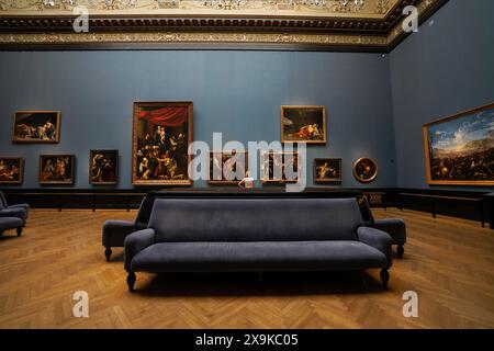 L'interno del museo di storia dell'arte di Vienna, noto come Kunsthistorisches Museum Wien o KHM. Donna nella sala espositiva della galleria d'arte con dipinti, divani, divani. Foto Stock