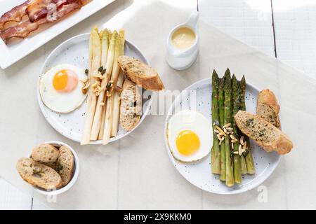 Asparagi verdi e bianchi serviti con uova, pancetta, pane all'aglio. Gli asparagi, che rappresentano le fibre alimentari, sono molto popolari in Germania durante Spargelzeit Foto Stock