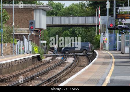 Passaggio ferroviario a livello di Rainham Kent con un furgone e un uomo che attraversano i binari Foto Stock