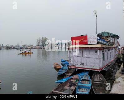 L'ufficio postale galleggiante di Srinagar, il kashmir ha attraccato case galleggianti e barche di legno in acque calme sotto un cielo coperto Foto Stock