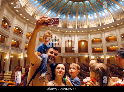 Bucarest, Romania. 1 giugno 2024. Una famiglia scatta selfie all'interno della sala principale della camera secondaria durante un evento a porte aperte che celebra la giornata internazionale dei bambini al Palazzo del Parlamento rumeno a Bucarest, Romania, 1° giugno 2024. Crediti: Cristian Cristel/Xinhua/Alamy Live News Foto Stock