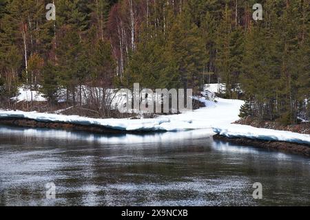 Fiume ghiacciato con un piccolo estuario nel nord della Svezia. Foto Stock