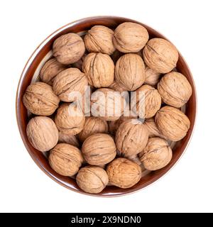 Noci nel guscio, in un recipiente marrone. Semi secchi non sgusciati del comune noce Juglans regia. Noci intere con conchiglie, utilizzate come snack, ecc. Foto Stock