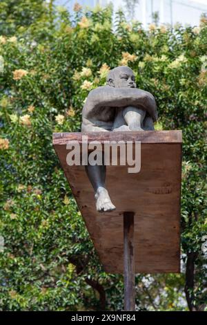 Statua sopraelevata dell'uomo seduto sulla filiale in Avenida Álvaro Obregón nel quartiere Roma Norte di città del Messico, Messico Foto Stock