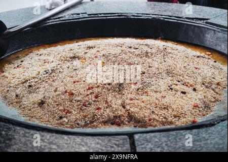 Il piatto della cucina uzbeka è il pilaf di riso in un grande calderone nella cucina di un ristorante asiatico nel centro di Tashkent Pilaf Besh Qozon in Uzbekistan Foto Stock