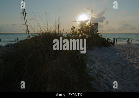 Ampia vista della spiaggia di Pass-a-Grille a St. Pete Beach, Florida, che guarda verso ovest al sole sulle verdi acque di mare e sulla sabbia. Al sole. Onde nell'acqua, Foto Stock