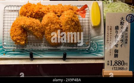 Tradizionale cotoletta di maiale impanata giapponese, tonkatsu, con cavolo e limone, prezzo in yen incluso Foto Stock