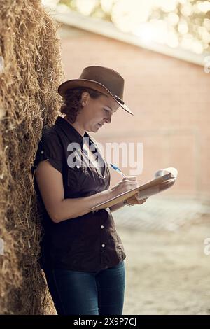 Donne, appunti e scritture per il programma agricolo, la pianificazione e la revisione per la manutenzione. Agricoltore, controllo e appunti in campagna per Foto Stock