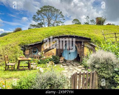 Pittoresca casa in stile hobbitstyle immersa in una lussureggiante campagna, caratterizzata da una porta unica, tetto verde e giardino sereno Foto Stock