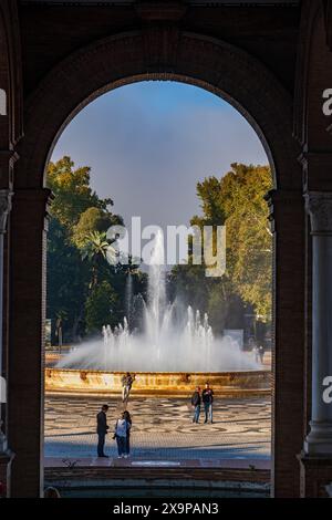 Siviglia, Andalusia, Spagna - 24 ottobre 2023 - Fontana in piazza Plaza de Espana nel Parco Maria Luisa, incorniciata da un arco di padiglione. Foto Stock