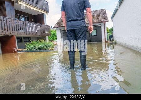 Feuerwehr Pumpt Wasser aus überflutetem Keller ab, Hochwasser, Überschwemmung in Affalterbach, Ortsteil von Pfaffenhofen an der ILM, 2. Juni 2024 Deutschland, Affalterbach, Ortsteil von Paffenhofen an der ILM, 2. Juni 2024, Feuerwehr Pumpt Wasse aus einem überschwemmten Heizungskeller und der Garage, geschädigter Hausbewohner mit Gummistiefeln auf seinem überschwemmten Grundstück, Hochwasser, Überschwemmungsgebiet, Die ILM ist nach Unwetter mit Dauerregen über die Ufer getreten, überschwemmt Wohngebiete und Felder, Katastrophenfall, Bayern *** pompe dei pompieri inondati Foto Stock