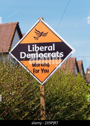 Logo e slogan del partito liberale democratico "Working for You” su un cartello su un sentiero a Faringdon, Oxfordshire, Inghilterra Foto Stock