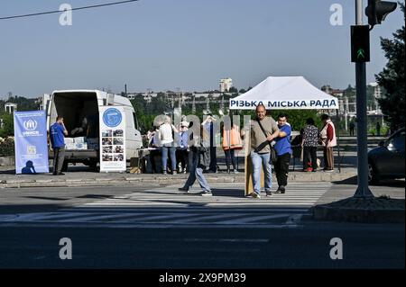 Non esclusivo: ZAPORIZHZHIA, UCRAINA - 1 GIUGNO 2024 - i locali ricevono aiuto dopo l'attacco missilistico russo a Zaporizhzhia, Ucraina sudorientale. A Zapor Foto Stock