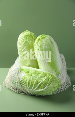 Cavoli cinesi freschi in sacchetto di spago su sfondo verde Foto Stock